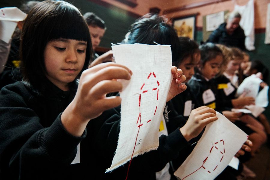 Students holding their sewing squares during the program Lessons from the Past at Rouse Hill Estate