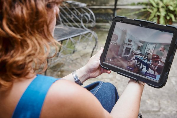 A visitor exploring the Vaucluse House virtual tour on the iPad while they sit in the internal courtyard