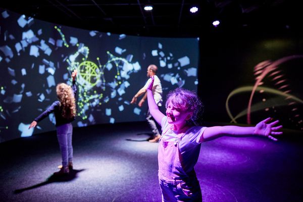 Visitors enjoying Maestro, an interactive space where light and sound respond to body movement, part of The People’s House: Sydney Opera House at 50 exhibition.
